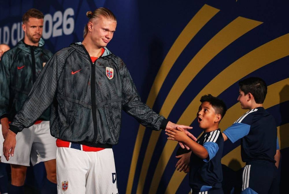 Erling Haaland greets young fans, reflecting the values of respect and humility his mother taught him from an early age.