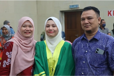 Thurayya Fadhilah (tengah) bersama kedua ibu bapanya ketika sesi pengumuman SPM 2022 di SMA MAIWP pada Khamis. 