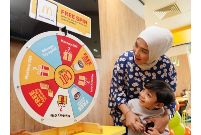 
Seorang kanak-kanak ceria sambil melihat apa yang diperolehnya semasa aktiviti pusing roda dalam program Cuti@McD.