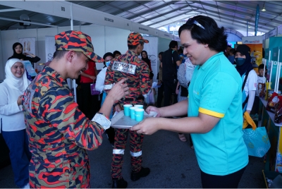 Salah seorang petugas memberikan produk kopi kepada anggota bomba.