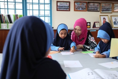 Faridah (dua, kanan) meninjau aktiviti murid-murid Tabika Pra Tahfiz Kemas di Tabika Kemas Lorong Gemia.