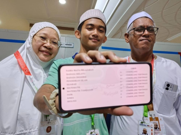 Muhammad Ameer bersama ibu bapanya menunjukkan keputusan cemerlang SPM diperolehnya. 