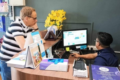 Abdul Hafiz Faizal (duduk) melakukan semakan daftar pesakit berkomputer yang mendapatkan rawatan fisioterapi di Passionate Health & Wealthcare baru-baru ini. 