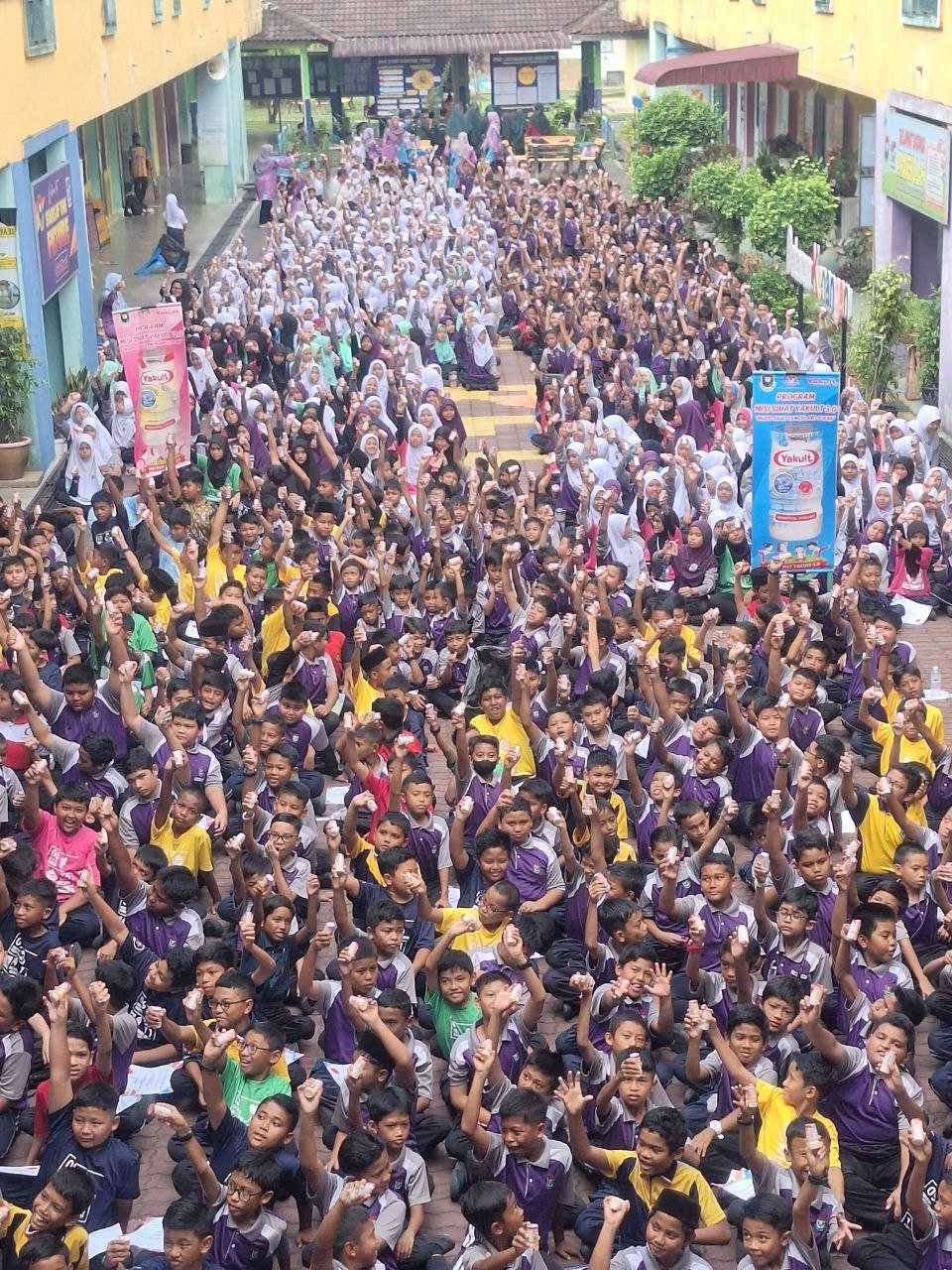 Murid-murid bersorak kegembiraan diberikan minuman Yakult secara percuma dalam Hari Penghadaman Sedunia. 