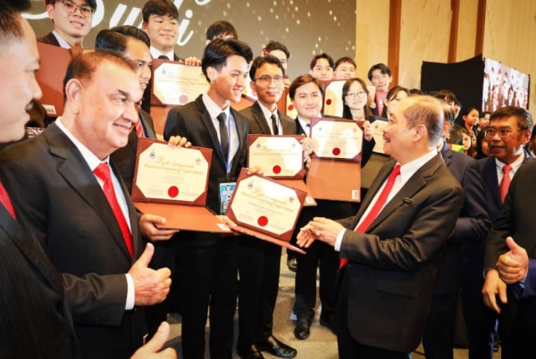 Hajiji (kanan) bersama pelajar cemerlang yang menerima anugerah dalam Majlis Penyampaian Biasiswa Cemerlang Negeri Sabah Siri Ke-35 di SICC, Kota Kinabalu.