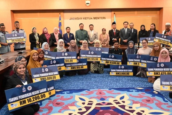 Mohd Arifin (tengah) bersama para penerima bantuan cermin mata TPNS di Menara Kinabalu pada Selasa. 