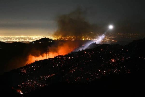 Cahaya lampu helikopter pemadam kebakaran menerangi lereng bukit berhampiran kejiranan Mandeville Canyon dan Encino, California 11 Januari lalu. Foto: AFP