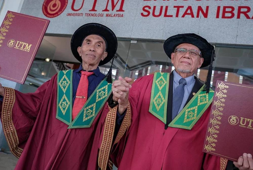 Mejar (B) Dr Kamarul Azman (kanan) bersama Dr Abdul Hakim selepas masing-masing berjaya meraih PhD daripada UTM. 