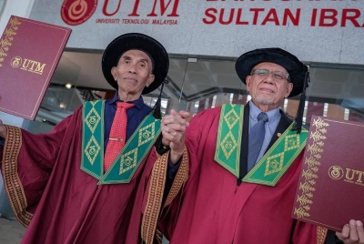 Mejar (B) Dr Kamarul Azman (kanan) bersama Dr Abdul Hakim selepas masing-masing berjaya meraih PhD daripada UTM. 