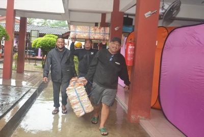 Petugas membawa barangan untuk mangsa banjir seperti tikar dan keperluan lain di PPS SK Kuala Besut 1.