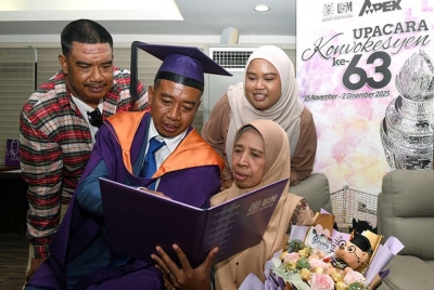 Mohd Khairul menunjukkan skrol Ijazah Sarjana Sains Kemasyarakat yang diterima kepada ibunya Sarinah (kanan). Turut sama, adiknya Mohd Khairi, 37, (kiri) dan Farah Waheeda, 32.