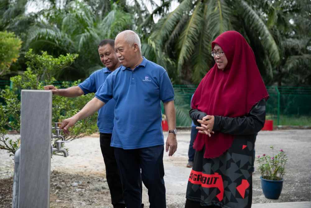  Ketua Pegawai Eksekutif PAAB, Zulkiflee Omar (tengah) meninjau tempat wuduk baharu bersama Norhayati di Sekolah Agama Gambut. 
