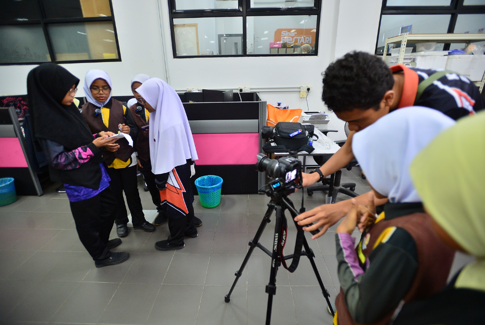 Peserta lain menjalankan aktiviti berkumpulan seperti biasa dengan bantuan guru pengiring.