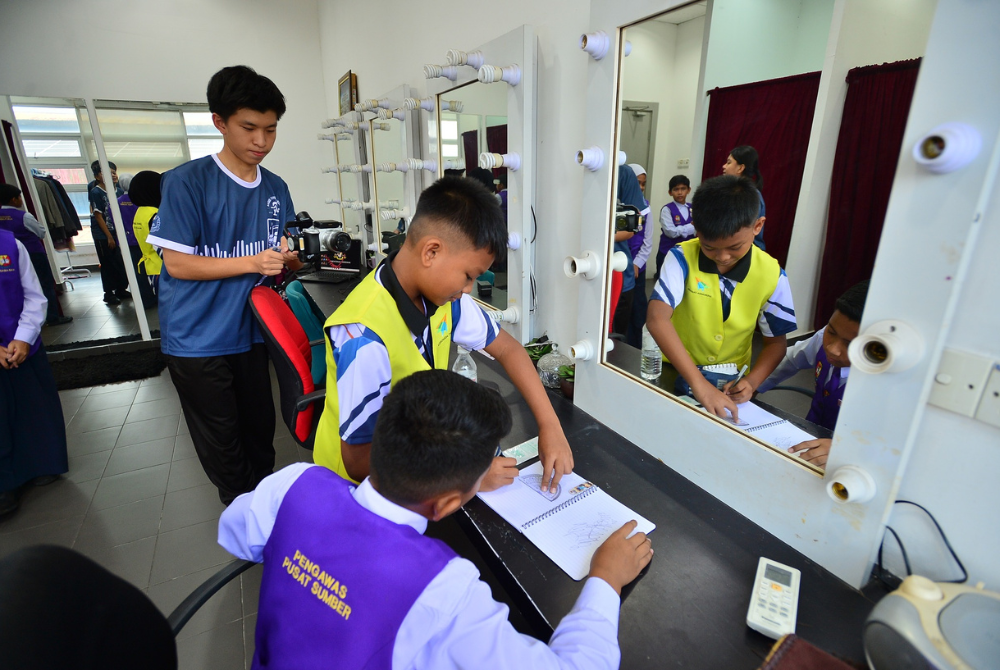 Hao Song (kiri) merakam ahli kumpulannya berlakon sewaktu proses menyiapkan tugasan video.