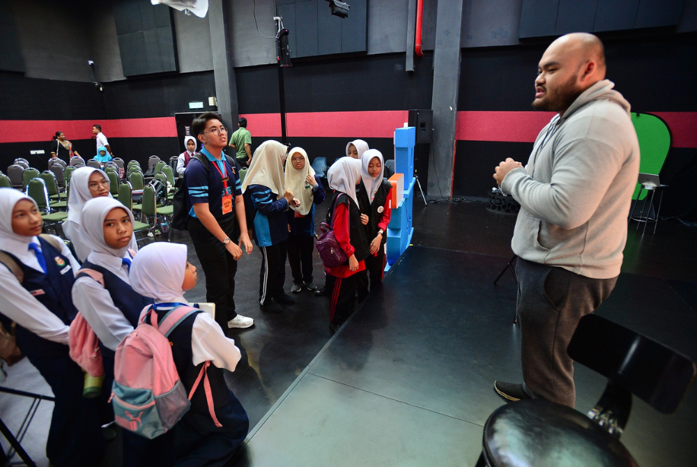 Kru produksi memberi tunjuk ajar untuk menyediakan tugasan berkumpulan.