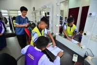 Hao Song (kiri) merakam ahli kumpulannya berlakon sewaktu proses menyiapkan tugasan video.