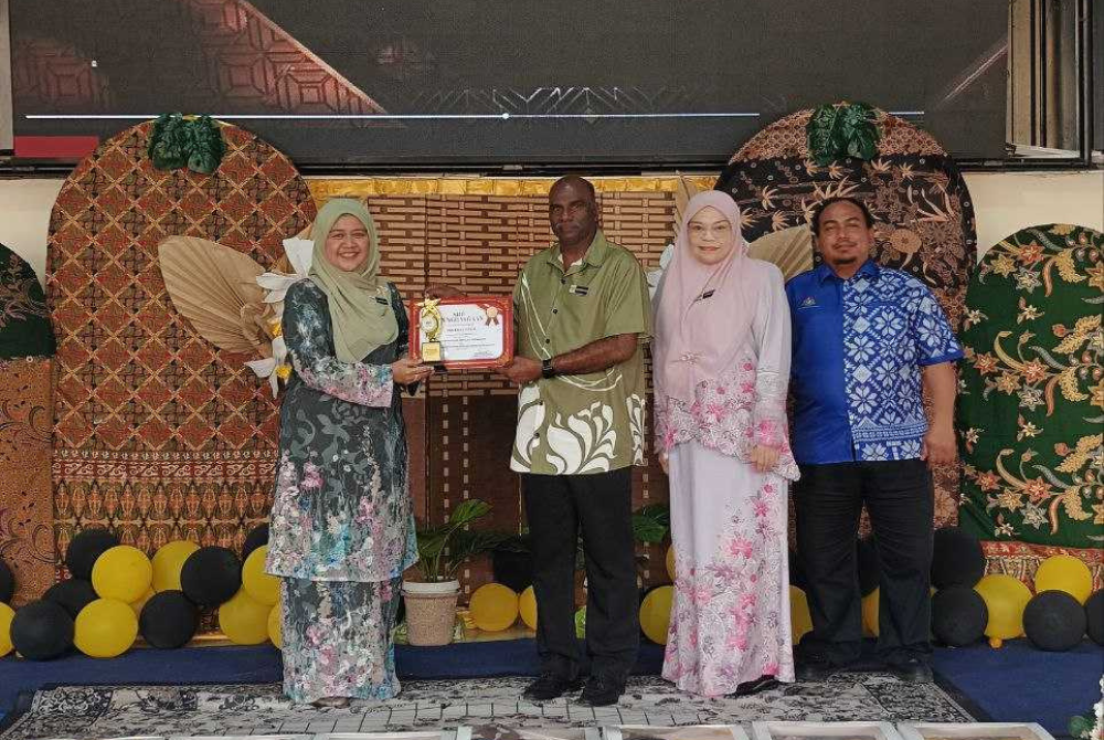 Penyerahan Anugerah Khas Sekolah Showcase yang disampaikan Surieyani (kiri) kepada Subramaniyan (tiga kanan)