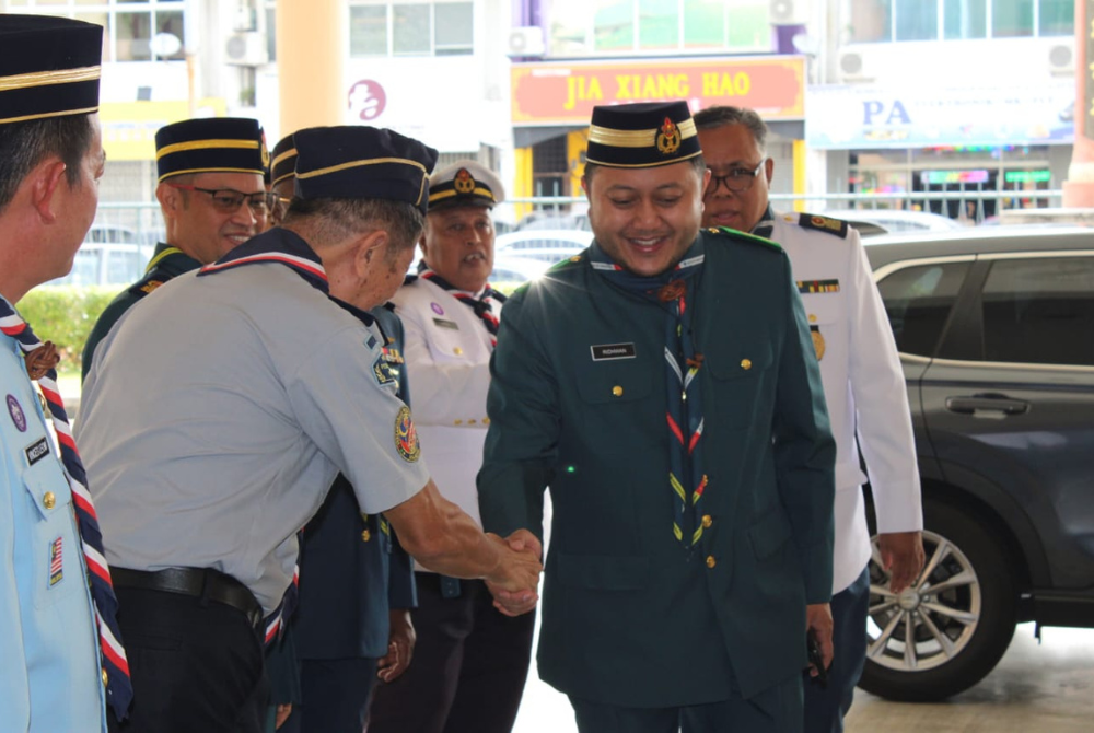 Datuk Mohd Ridhwan (kanan) bersalaman dengan pegawai lain semasa perarakan masuk ke dewan.