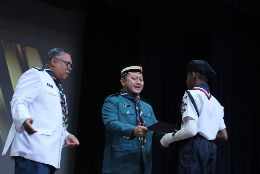 Datuk Mohd Ridhwan menyampaikan pingat dan sijil kepada ahli Pengakap.