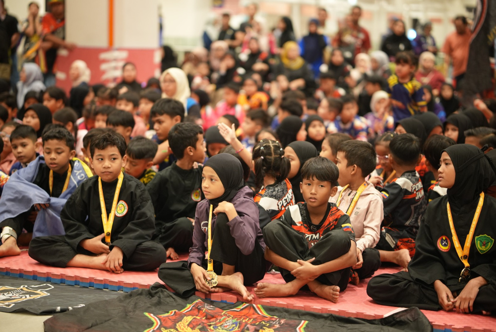 Pesilat cilik yang telah selesai sesi masing-masing memberikan sokongan kepada pesilat lain.
