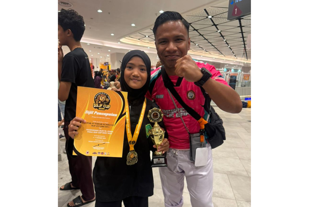 Mohd Hafizam bersama pesilat muda daripada Persatuan Silat Lincah Bandar Tasik Selatan, Nur Ainnis Qaisara menunjukkan trofi, pingat dan sijil hasil kejayaannya.