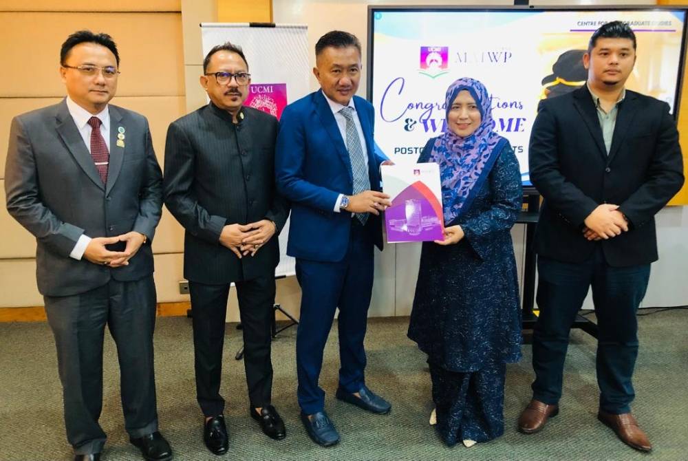 Nor Hasnal (tiga dari kiri) turut menyerahkan cenderamata kepada Noor Inayah, menandakan penghargaan atas sumbangan dan kehadirannya dalam majlis tersebut.