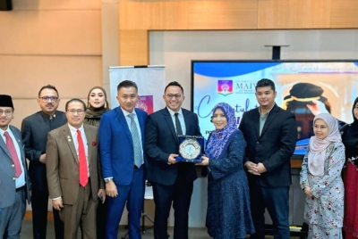 Penasihat Undang-Undang Diraja DPDDM, Ahmad Nazib Johari (tengah) menyampaikan cenderamata kepada Noor Inayah sejurus berakhirnya majlis khas di Auditorium UCMI.