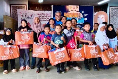 Azran Fitri (belakang) bersama sebahagian daripada 300 murid yang menerima sumbangan set kelengkapan 'Kembali Ke Sekolah - PEMASIK' di SK Seri Dusun. 