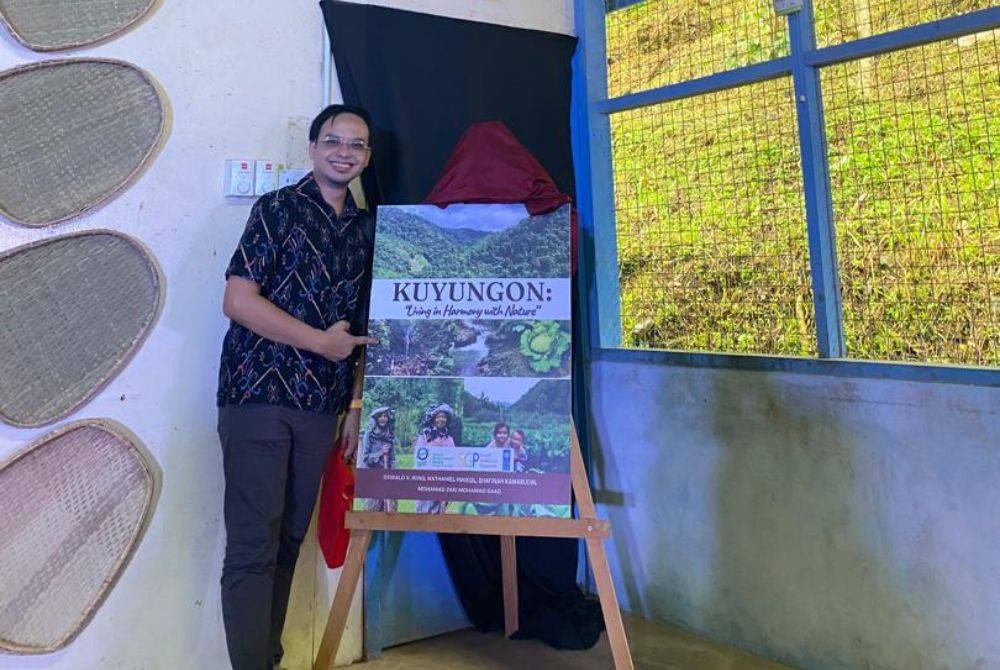 Mohamad Zaki bersama placard buku separa ilmiah di Sabah.