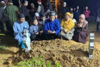 Mazli (tengah) bersama isteri dan enam anaknya di pusara Allahyarhamah Syakirah Hanan selepas selesai pengebumian di Tanah Perkuburan Islam Kubur Besar Kuala Bedah, di Kuala Terengganu sekitar jam 12.30 tengah malam pada Isnin. 