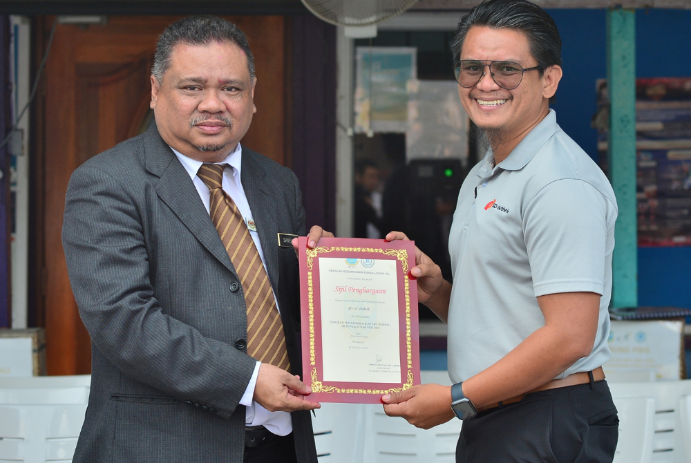 Mohd Nor (kanan) menerima sijil penghargaan daripada Guru Besar SK Sungai Judah (A), Samsul Fadilah (kiri).