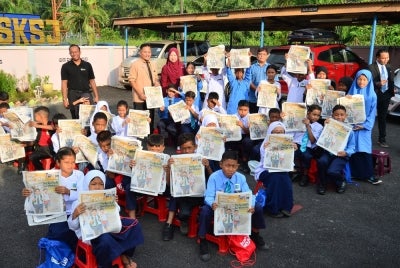 Pelajar menunjukkan sisipan Sinar Bestari siaran 12 Januari lalu.