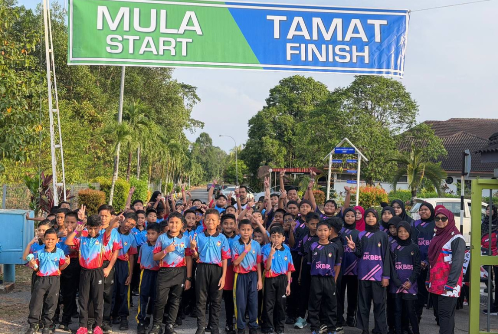 Pelajar bergambar di garisan pemula dan penamat sebelum wisel dibunyikan.