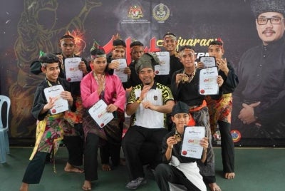 Atlet DBTC meraikan kejayaan bersama Cikgu Fuad (tengah) selepas mencatat pencapaian cemerlang dalam kejohanan silat yang disertai.