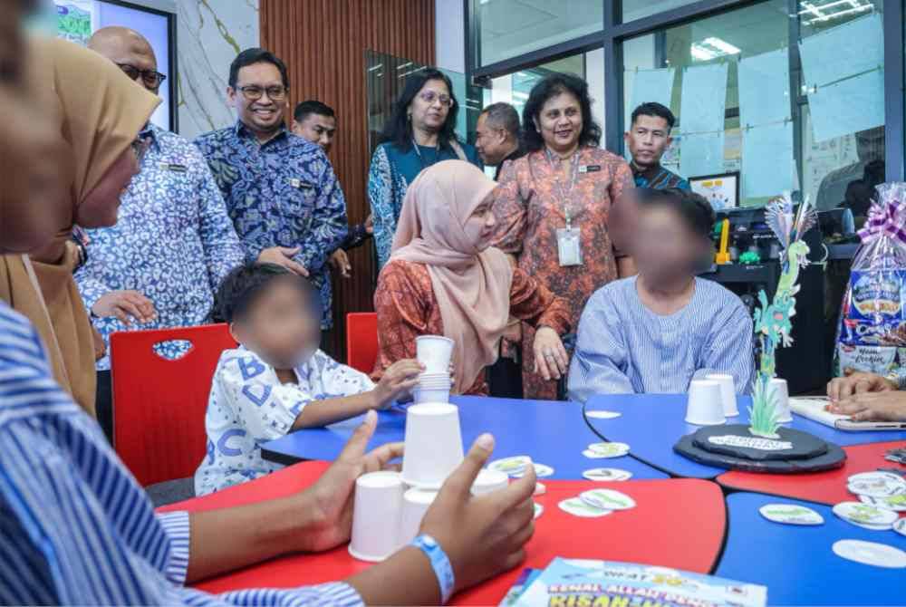 Fadhlina (duduk di tengah) beramah mesra dengan para pesakit pada Perasmian Program Sekolah Dalam Hospital di Hospital Seberang Jaya, Pulau Pinang.