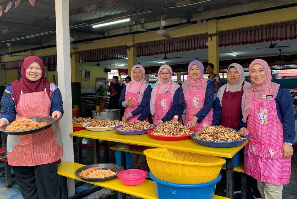 Guru-guru wanita SK Pandamaran Jaya menyediakan bahan mentah sebelum dimasukkan ke dalam kawah untuk menyiapkan bubur lambuk.