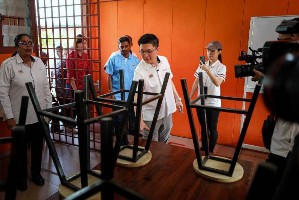 Kah Woh (tiga dari kanan) melihat persekitaran ruang kelas ketika hadir meninjau Projek Daif Sekolah Jenis Kebangsaan Tamil (SJKT) Gopeng hari ini. 