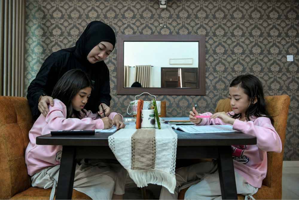 Shahira membantu dua anak saudaranya, Khayla Zahra Mohd Zahir, 11, dan Khayla Zulfa Mohd Zahir, 9, menjalani PdPR.