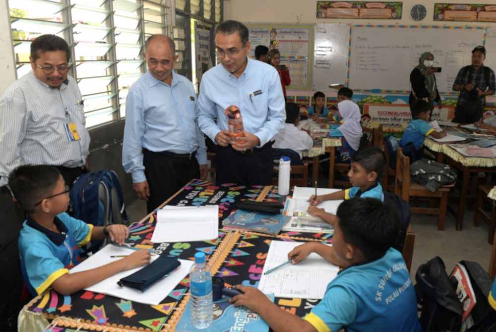 Mohamad Dziauddin (kanan) melawat SK Sungai Gelugor bagi meninjau langkah proaktif dengan memperkukuhkan persediaan sekolah dalam menghadapi gelombang cuaca panas ketika ini. 