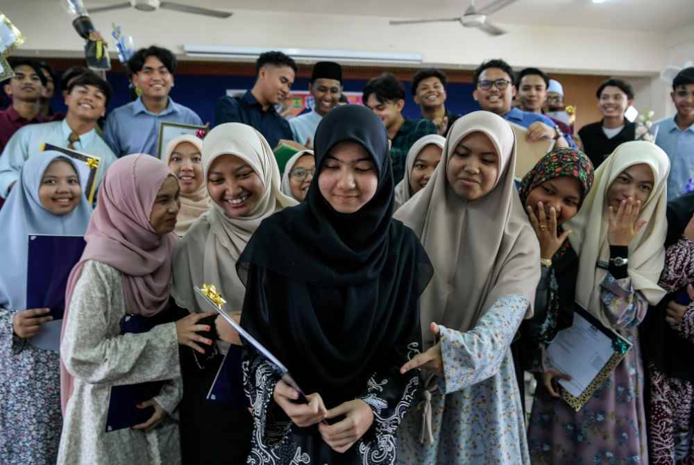 Huda Rasheeda (tengah) bersama rakan-rakan sambil menunjukkan keputusan 10A dalam SPM.