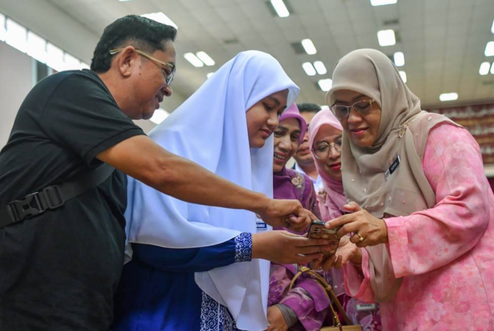 Pengarah Jabatan Pendidikan Negeri (JPN) Kelantan, Siti Norina Muhamad (kanan) bersama Nur Syahirah Syazwani melihat keputusan peperiksaan SPM 2025 melalui pautan laman web rasmi Lembaga Peperiksaan Malaysia.