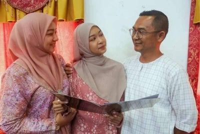 Putri Noor Syahida (tengah) berkongsi kejayaan bersama bapa Mohd Syah Rizal Sulong, 48, dan ibu Norlida Mohd Nor, 42, setelah memperoleh keputusan cemerlang 8A pada Majlis Pengumuman Keputusan SPM di Sekolah Menengah Sains Sultan Mahmud (SESMA).