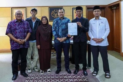 Fakhrul Iman (dua dari kanan) bersama ibu bapanya merakamkan momen indah bersama Asyraf Wajdi.