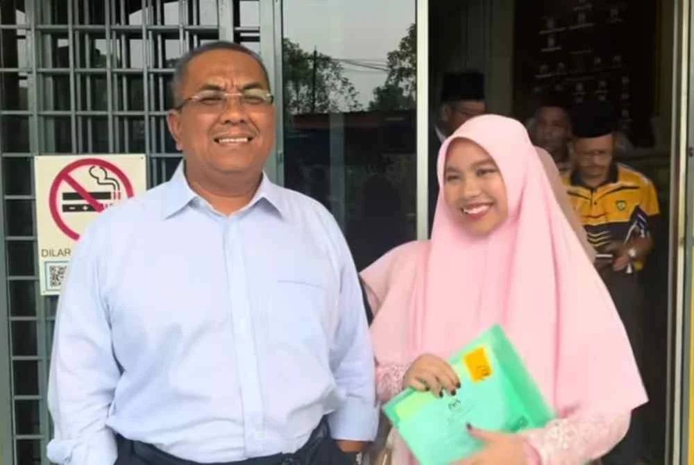 Sanusi bersama Nur Hana semasa mengambil keputusan SPM di Maktab Mahmud Padang Terap pada Selasa.