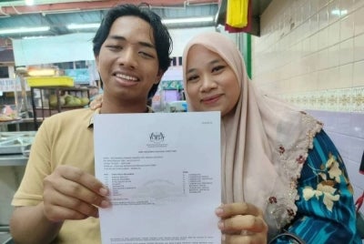 Muhammad Fiqkrie bersama Zaiton menunjukkan slip keputusan SPM yang diperoleh baru-baru ini.