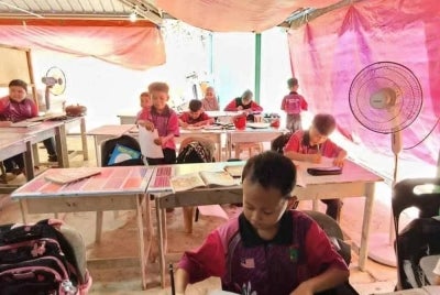 Murid-murid terpaksa belajar di bawah khemah kerana tidak mempunyai bangunan sekolah sendiri.