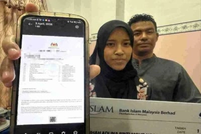 Nur Faqihah Adlina (kiri) menunjukkan keputusan SPM yang cemerlang.