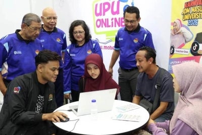 Dr Azlinda, Pengerusi LPU UUM, Tan Sri Dr Mazlan Yusuf dan Dr Ahmad Martadha menyaksikan pelajar dan ibu bapa mendapatkan khidmat nasihat permohonan melalui UPUOnline.