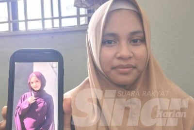 Nur Fatimatul Zahra menunjukkan gambar arwah adiknya, Nur Fatimatul Hawa ketika ditemui di rumahnya pada Isnin. 