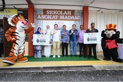 Kah Woh (tiga kiri) ketika hadir pada majlis penyerahan inisiatif Sekolah Angkat MADANI (SAM) pada Khamis.